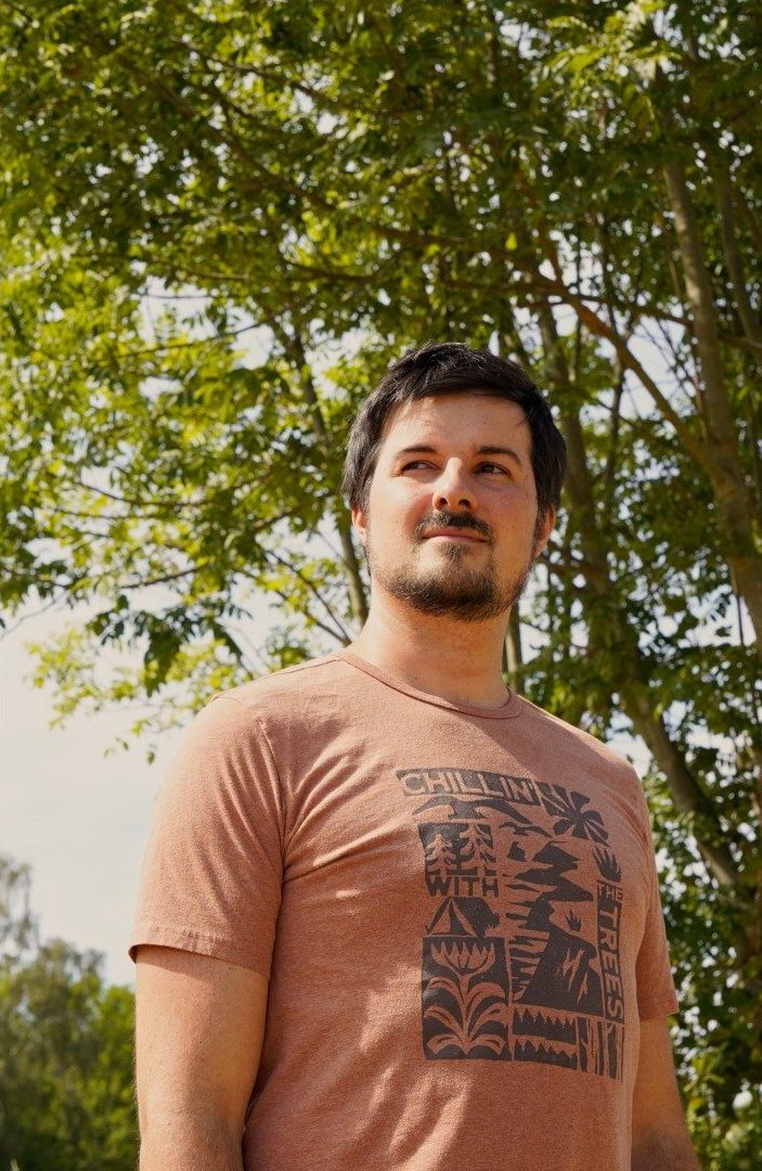 Alex, cofondateur de Petit d'Auvergne, en extérieur sous les arbres