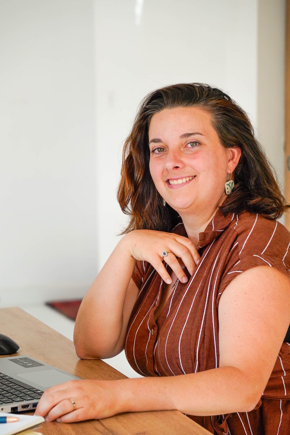 Laeticia, cofondatrice de Petit d'Auvergne, souriante à son bureau devant son ordinateur portable